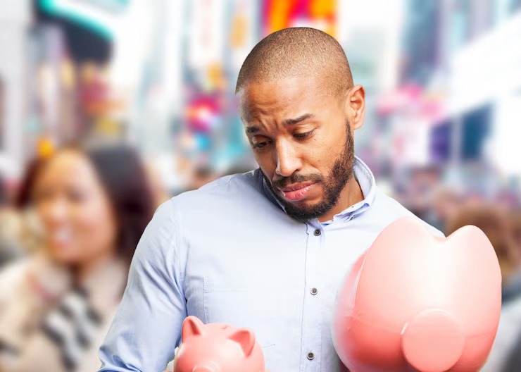 man staring at hos piggy bank