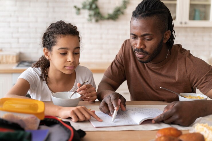 picture showing father homeschooling his daughter as they eat