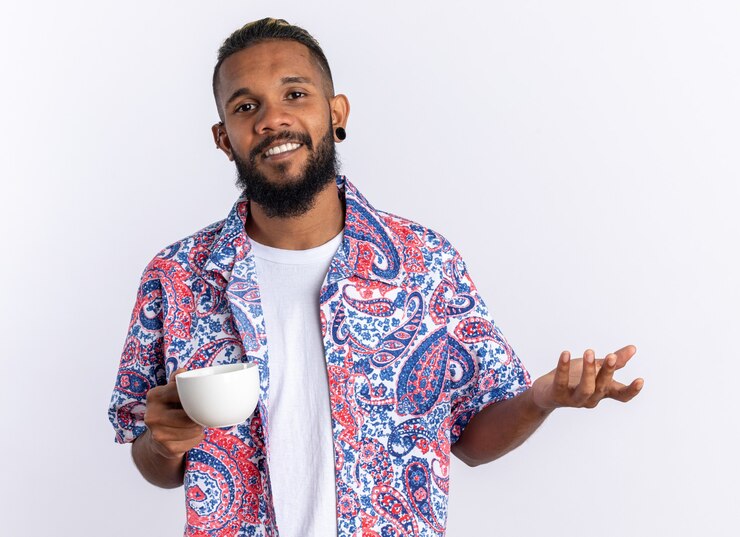 picture showing a young man expressing his views about life on the island while taking a cup of coffee