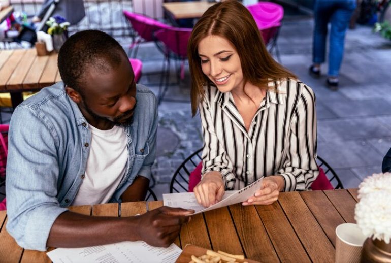 couple on a budget date going through the menu